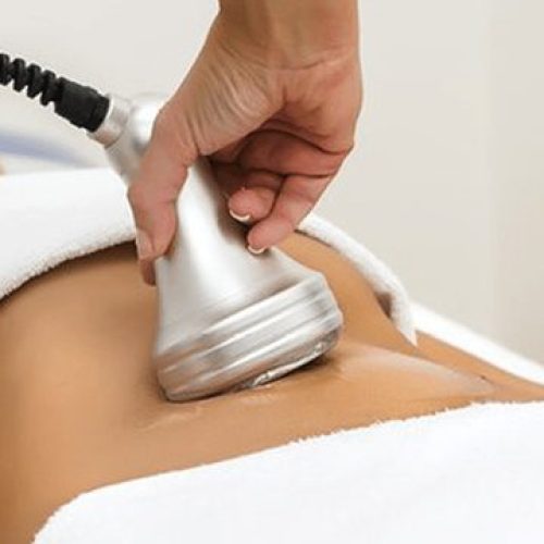 A person is getting their back waxed with an electric device.